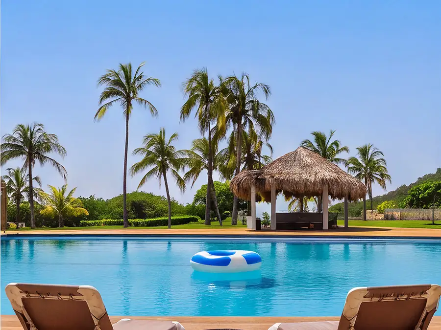 Piscina con palapa y camastros